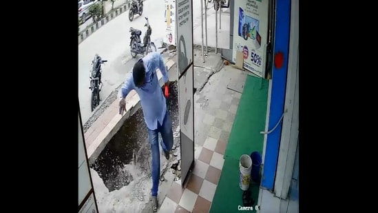 A screengrab from the video that shows the man's narrow escape as the footpath caves in.&nbsp;(Reddit/@CAEmotionalEkambaram)