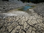 File photo of cracked and dry earth on the banks of Le Broc lake, as a historical drought hits France, August 5, 2022.