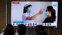 FILE PHOTO: People watch a TV broadcasting a news report on the coronavirus disease (COVID-19) outbreak in North Korea, at a railway station in Seoul, South Korea.