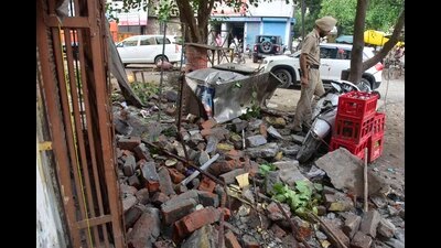 Police investigating the spot where the parapet wall of a building collapsed on Gill Road on Monday. (Gurpreet Singh/HT)