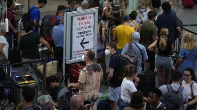 Train passengers wait with their luggage at Atocha train station in Madrid, Spain, Monday, Aug. 8, 2022. Hundreds of passengers were stranded Monday morning in Madrid and Barcelona train stations as the bullet-train railway linking both cities was sabotaged during the night. The Spanish railway infrastructure company ADIF reported the theft of some 600 meters of optic fiber cable during the night in the Catalonia region which led to the suspension of the train service for most of Monday morning. &nbsp; (AP Photo/Paul White)