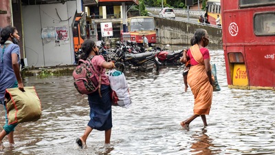 Commuters wade through a waterlogged road after heavy rain in Kochi. (PTI)