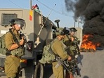 Israeli security forces take positions as Palestinians burn tyres during clashes after an attempt by Isreali settlers to remove Palestinian flags east of the West Bank village of Qalqiliya, on May 31, 2022.(AFP) Israeli security forces take positions as Palestinians burn tyres during clashes after an attempt by Isreali settlers to remove Palestinian flags east of the West Bank village of Qalqiliya, on May 31, 2022.(AFP)