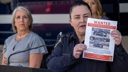 Albuquerque Police Deputy Chief of Investigations Cecily Barker holds a flyer with photos of a car wanted in connection with Muslim men murdered as Governor Michelle Lujan Grisham looks on in Albuquerque, New Mexico. (Adolphe Pierre-Louis/Albuquerque Journal via AP)