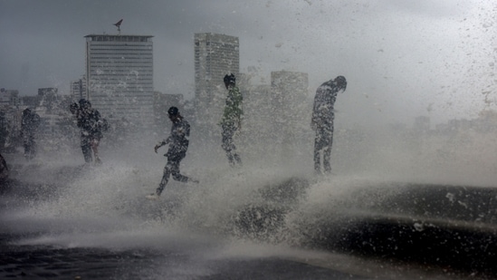 People enjoy an evening in the rain as sea waves lash the seashore at Marine Drive during high tide, in Mumbai, India, on July 07, 2022.(Satish Bate/HT PHOTO) People enjoy an evening in the rain as sea waves lash the seashore at Marine Drive during high tide, in Mumbai, India, on July 07, 2022.(Satish Bate/HT PHOTO)