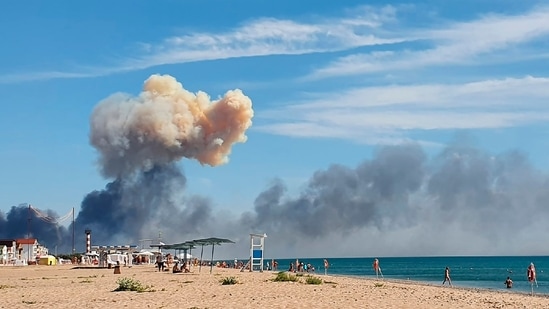 Rising smoke can be seen from the beach at Saky after explosions were heard from the direction of a Russian military airbase near Novofedorivka, Crimea, Tuesday August 9, 2022. (UGC via AP)