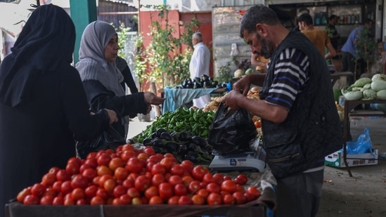 Palestinians buy fresh produce from street stalls in Rafah town in the southern Gaza Strip, as a truce with Israel holds following three days of conflict. (Photo by SAID KHATIB/AFP) Palestinians buy fresh produce from street stalls in Rafah town in the southern Gaza Strip, as a truce with Israel holds following three days of conflict. (Photo by SAID KHATIB/AFP)