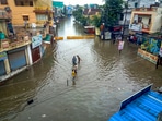 &nbsp;Locals wade through a waterlogged street following incessant monsoon rains, in Indore.(PTI)
