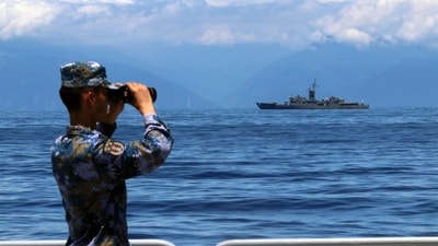 FILE - In this photo, a People's Liberation Army member looks through binoculars during military exercises as Taiwan's frigate Lan Yang is seen at the rear on Aug. 5, 2022. China on Wednesday, Aug. 10, reaffirmed its threat to use military force to bring self-governing Taiwan under its control, amid threatening Chinese military exercises that have raised tensions between the sides to their highest level in years. (AP) FILE - In this photo, a People's Liberation Army member looks through binoculars during military exercises as Taiwan's frigate Lan Yang is seen at the rear on Aug. 5, 2022. China on Wednesday, Aug. 10, reaffirmed its threat to use military force to bring self-governing Taiwan under its control, amid threatening Chinese military exercises that have raised tensions between the sides to their highest level in years. (AP)