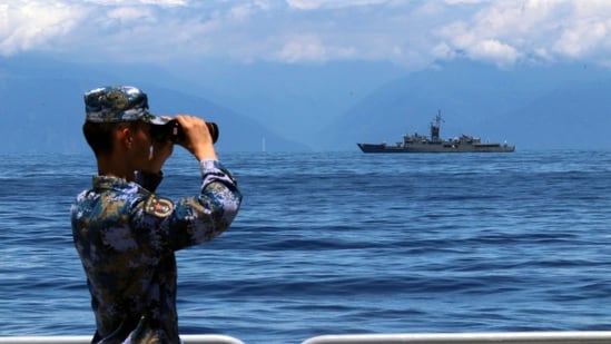 FILE - In this photo, a People's Liberation Army member looks through binoculars during military exercises as Taiwan's frigate Lan Yang is seen at the rear on Aug. 5, 2022. China on Wednesday, Aug. 10, reaffirmed its threat to use military force to bring self-governing Taiwan under its control, amid threatening Chinese military exercises that have raised tensions between the sides to their highest level in years.&nbsp;(AP)