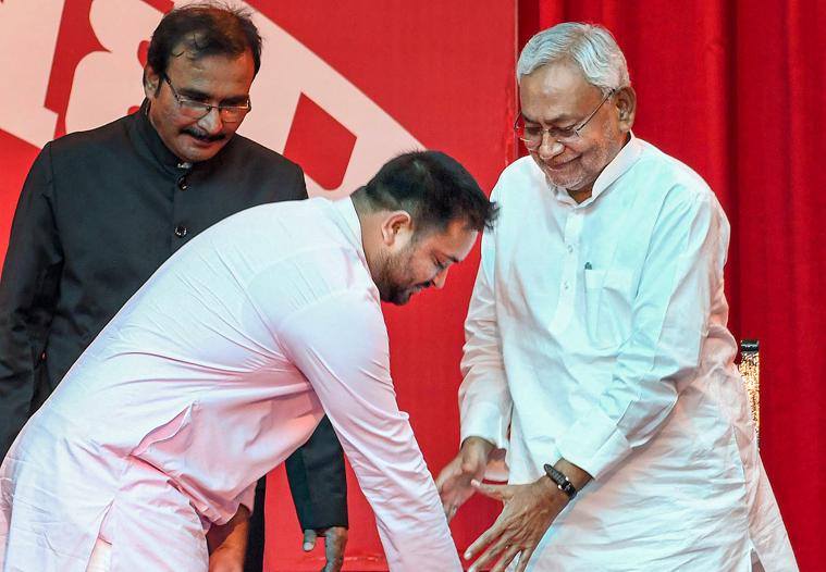 RJD leader Tejashwi Yadav seeks blessings from Bihar chief minister Nitish Kumar after taking oath as deputy chief minister at the oath ceremony at the Raj Bhavan in Patna (PTI)