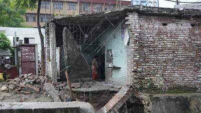 A woman looks at the remains of a house damaged in flash floods on the outskirts of Jammu on Thursday. (AP) A woman looks at the remains of a house damaged in flash floods on the outskirts of Jammu on Thursday. (AP)