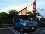 A Rivian R1T electric pickup truck sits parked outside a Tesla Inc. location in Hawthorne, California, on August 9, 2022.(AFP) A Rivian R1T electric pickup truck sits parked outside a Tesla Inc. location in Hawthorne, California, on August 9, 2022.(AFP)