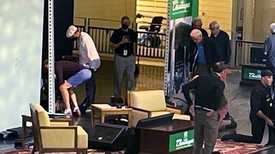 Author Salman Rushdie, behind screen left, is tended to after he was attacked during a lecture in New York. (AP) Author Salman Rushdie, behind screen left, is tended to after he was attacked during a lecture in New York. (AP)
