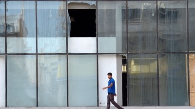A picture taken on August 12, 2022, shows shattered glass as a man walks in front of the building where according to Saudi officials, a suspect in a deadly 2015 Islamic State group attack on a Saudi mosque, blew himself up while being arrested by security forces in Jeddah this week. (AFP) A picture taken on August 12, 2022, shows shattered glass as a man walks in front of the building where according to Saudi officials, a suspect in a deadly 2015 Islamic State group attack on a Saudi mosque, blew himself up while being arrested by security forces in Jeddah this week. (AFP)