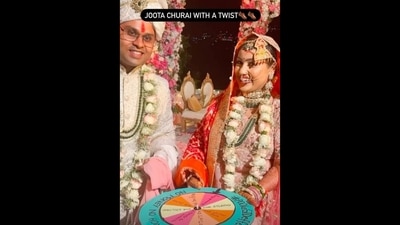 A screengrab from the video. It shows the bride and the groom with a spinning wheel for 'Joota Churai' ritual. (Instagram/@callmepooooo) A screengrab from the video. It shows the bride and the groom with a spinning wheel for 'Joota Churai' ritual. (Instagram/@callmepooooo)