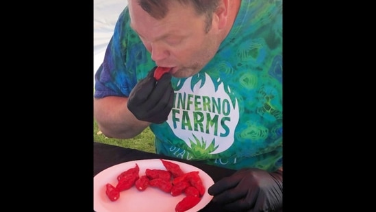 The image shows Gregory Foster eating bhut jolokia chilli peppers for world record.(Guinness World Records)