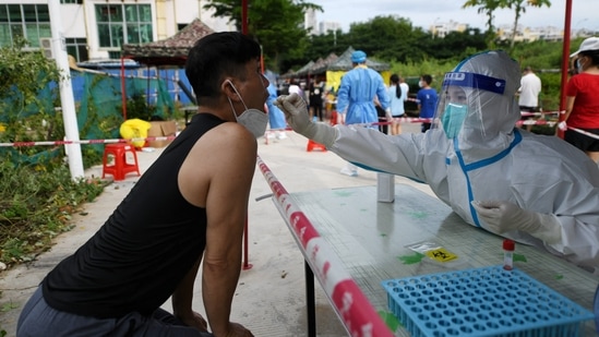 A medical worker takes a swab sample from a resident for the nucleic acid test at a makeshift testing site, amid lockdown measures to curb the coronavirus disease (Covid-19) outbreak in Sanya, Hainan province, China&nbsp;(VIA REUTERS)