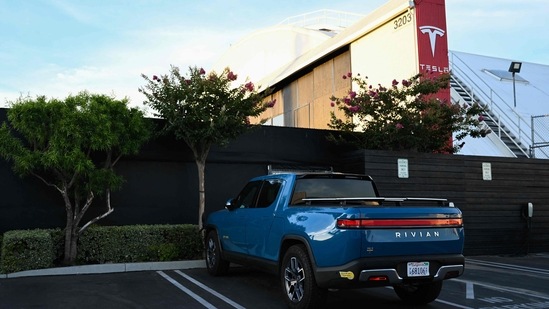 A Rivian R1T electric pickup truck sits parked outside a Tesla Inc. location in Hawthorne, California, on August 9, 2022.(AFP) A Rivian R1T electric pickup truck sits parked outside a Tesla Inc. location in Hawthorne, California, on August 9, 2022.(AFP)