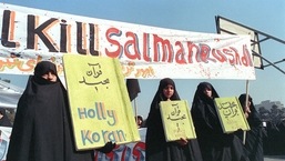 Nesta foto de arquivo tirada em 17 de fevereiro de 1989, mulheres iranianas são vistas segurando faixas que dizem "Holly Koran" e "Mate Salman Rushdie" durante uma manifestação contra o escritor britânico Salman Rushdie em Teerã.