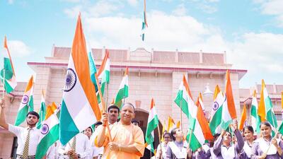 Uttar Pradesh chief minister Yogi Adityanath waves the Tricolour with schoolchildren in Lucknow on Saturday. (Twitter Photo)