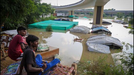 Residents living along the bank of Yamuna river relocate to higher grounds as water level started to flow above the danger level, at Mayur Vihar, on Saturday. (Sanchit Khanna/HT Photo)