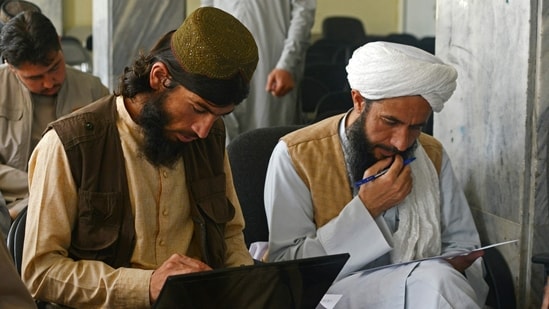 Taliban member Gul Agha Jalali (L) attends a computer science class at the Ministry of Transport and Civil Aviation in Kabul.(AFP)