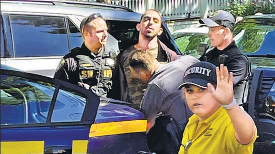 Law enforcement officers detain the attacker outside the Chautauqua Institution. (AP)