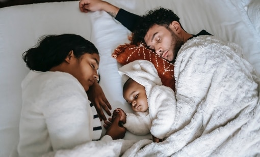 Baby sleeping in outlet bed with parents