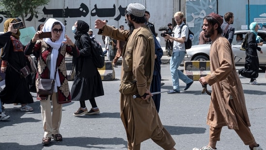 Taliban fighters walk as they fire in air to disperse Afghan women protesters in Kabul on Saturday, August 13, 2022. (Photo by Wakil KOHSAR/AFP)