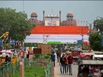 Commuters walk past the stacked containers in the guise of Indian national flag at Red Fort on the eve of India's Independence Day in New Delhi on August 14, 2022. (Photo by Sajjad HUSSAIN/AFP)