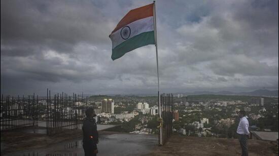 A tricolour is hoisted atop a building at Karve road, near SNDT College. (Pratham Gokhale/HT Photo)