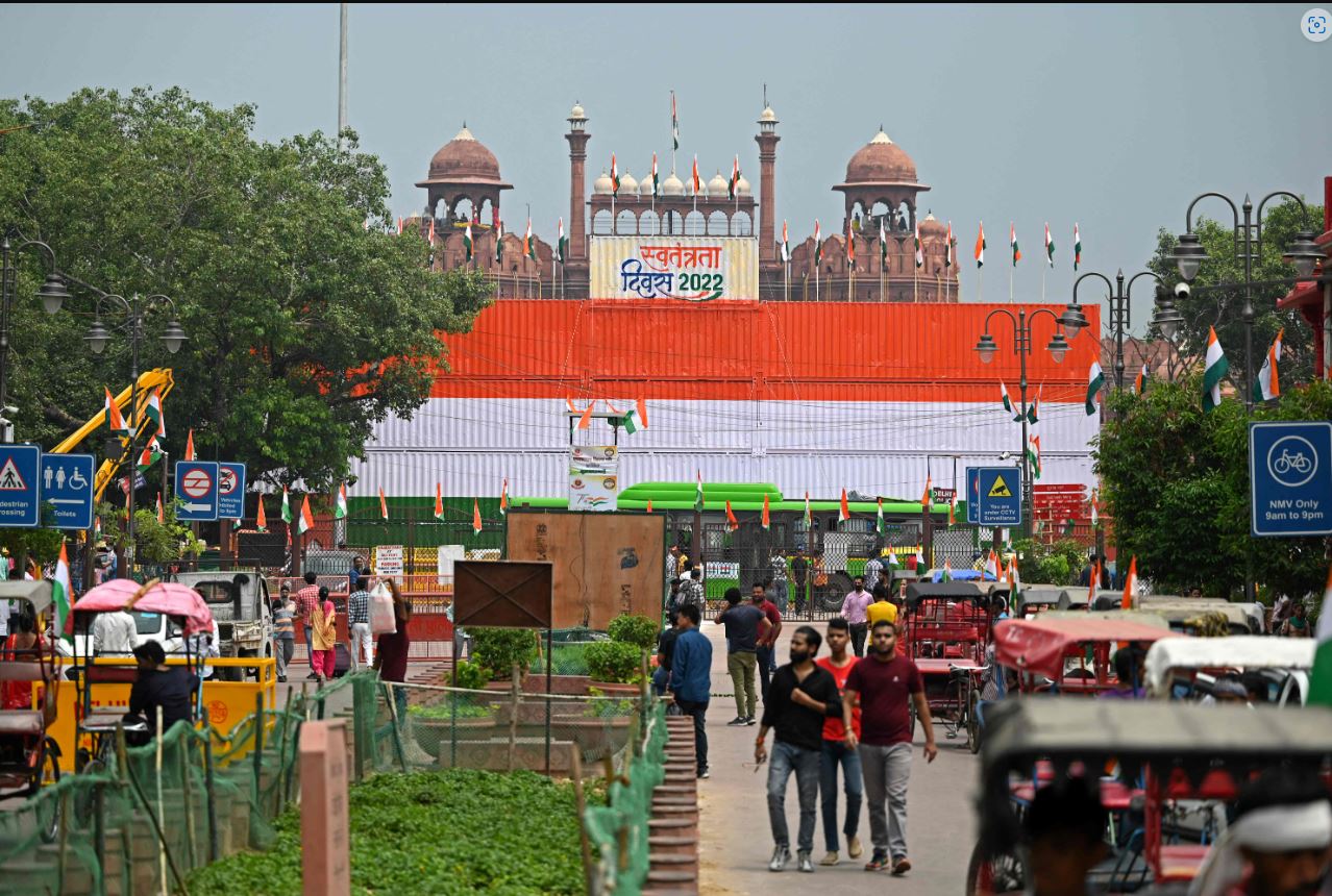 Commuters walk past the stacked containers in the guise of Indian national flag at Red Fort on the eve of India's Independence Day in New Delhi on August 14, 2022. (Photo by Sajjad HUSSAIN/AFP)