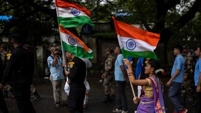 A girl walks carrying Indian flag along with army soldiers during a ceremony to celebrate 75 years of India's Independence in Mumbai, August 14, 2022 (AP)