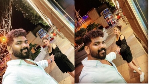 The couple smiled and posed for the camera as they held hands while taking a walk at night. The couple smiled and posed for the camera as they held hands while taking a walk at night.