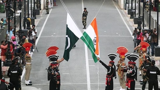 Pakistani Rangers (wearing black uniforms) and BSF personnel lower their national flags during a parade at the Attari-Wagah border in Punjab.(Reuters file )