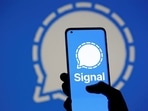 The Signal messaging app logo is seen on a smartphone, in front of the same displayed same logo, in this illustration.(Reuters)