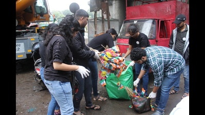 Pune residents collect discarded flags from Karve road on Tuesday (HT PHOTO)