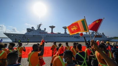 Workers wave China's and Sri Lanka's national flags upon the arrival of China's research and survey vessel, the Yuan Wang 5 at Hambantota port on Tuesday. (AFP) Workers wave China's and Sri Lanka's national flags upon the arrival of China's research and survey vessel, the Yuan Wang 5 at Hambantota port on Tuesday. (AFP)