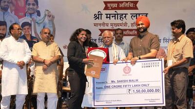 Haryana CM ML Khattar along with state sports minister Sandeep Singh felicitates Commonwealth Games gold medallist wrestler Sakshi Malik during a ceremony in Gurugram on Tuesday. (Ht Photo)