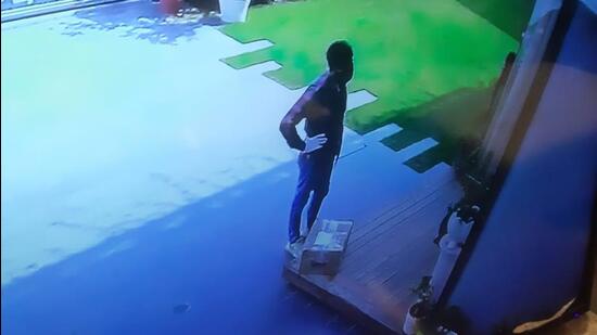 The accused, posing as delivery person, waiting outside the house in Sector 35 in Chandigarh on Tuesday. (HT File)