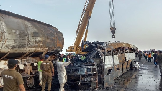 Police officers and workers remove the wreckage of a bus that collided with an oil tanker along a highway in Uch Sharif near Multan, Pakistan, Tuesday, Aug. 16, 2022.(AP) Police officers and workers remove the wreckage of a bus that collided with an oil tanker along a highway in Uch Sharif near Multan, Pakistan, Tuesday, Aug. 16, 2022.(AP)