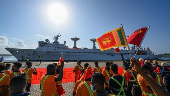 Workers wave China's and Sri Lanka's national flags upon the arrival of China's research and survey vessel, the Yuan Wang 5 at Hambantota port on Tuesday.(AFP)
