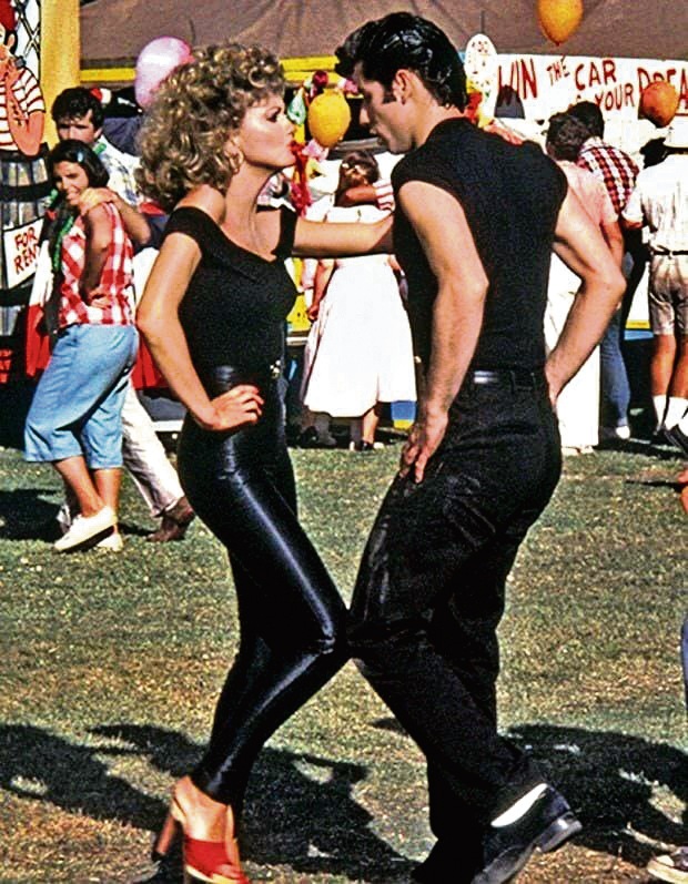 A still from the musical Grease, in which she can be seen in a black off-shoulder top and leather pants A still from the musical Grease, in which she can be seen in a black off-shoulder top and leather pants