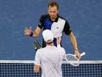 Daniil Medvedev, background, of Russia, shakes hands with Botic van de Zandschulp, of the Netherlands, after their match at the Western & Southern Open tennis tournament Tuesday, Aug. 16, 2022, in Mason, Ohio. (AP Photo/Jeff Dean)