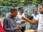 A man offers sweets to people convicted for rape and murder in the Bilkis Bano case of the 2002 post-Godhra riots, after they came out of the Godhra sub-jail after the Gujarat government allowed their release under its remission policy, in Godhra, Monday, Aug. 15, 2022. (PTI Photo)(