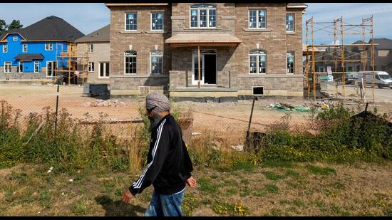 A person walks in front of new homes under construction in Brampton, Ontario, Canada. Between 2016 and 2021, the number of Punjabi speakers increased by 49% to 520,000. (REUTERS)