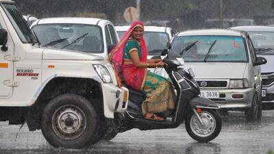 Commuters caught in the showers in Sector 20, Chandigarh, on Friday. (Ravi Kumar/HT)