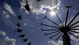 File image of people riding on a swing in a carnival.