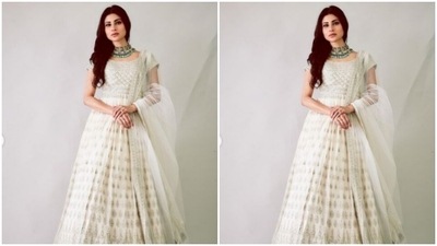 The ankle-length anarkali came with intricate prints in silver shades and silver zari work at the borders. She further added more ethnic vibes to her look with a white dupatta featuring white zari work at the borders. (Instagram/@imouniroy)